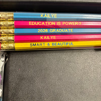 Colorful pencils with personalized text on a dark surface