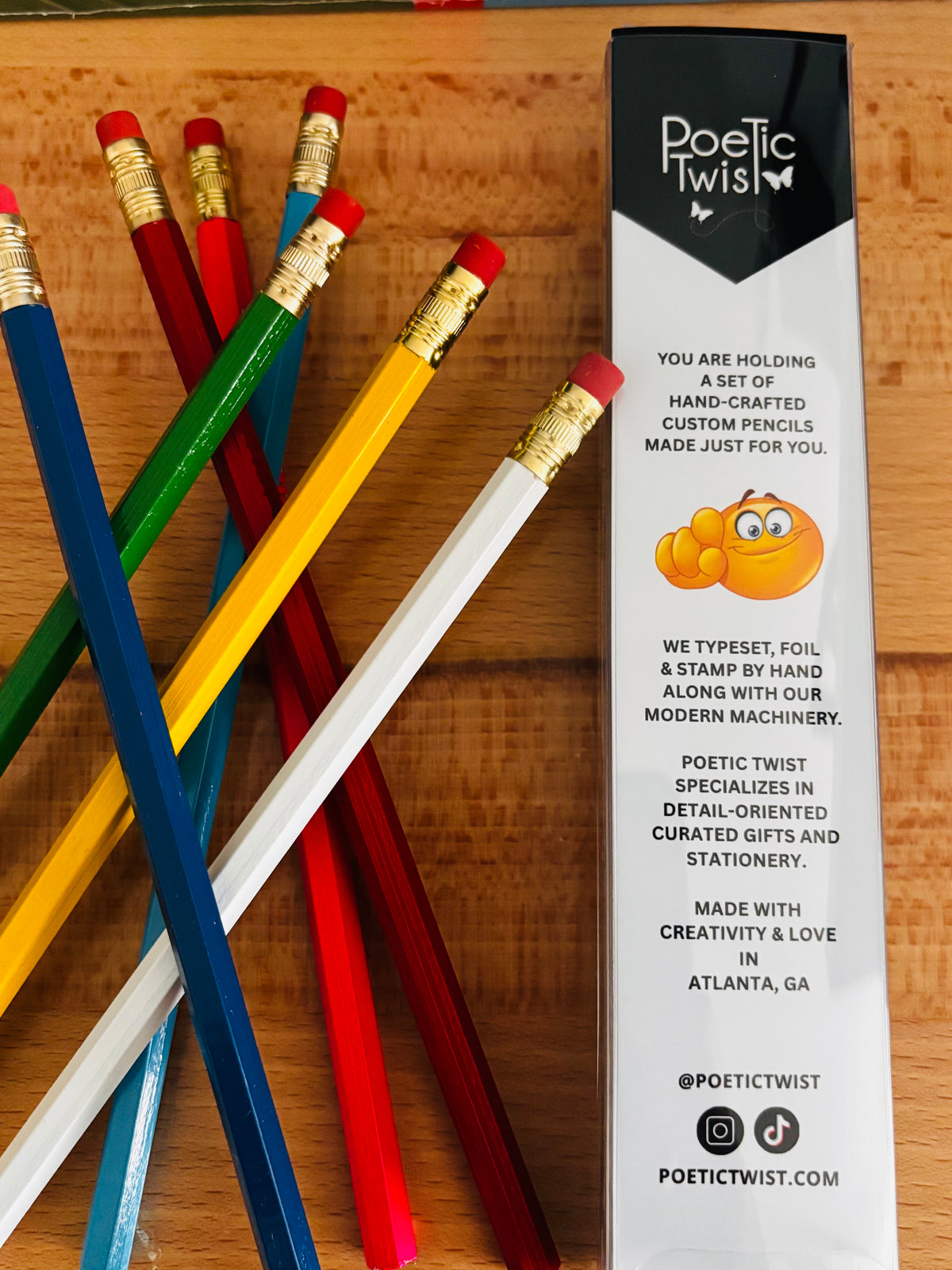 Set of colorful pencils with a Poetic Twist packaging on a wooden surface